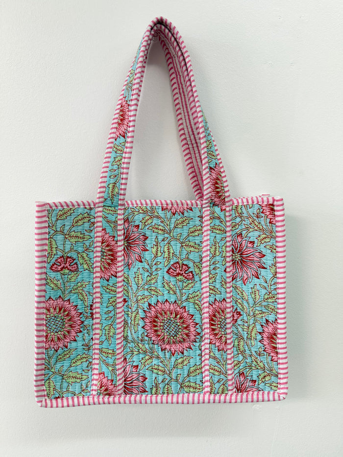 Floral patterned tote bag with striped handles on a white background