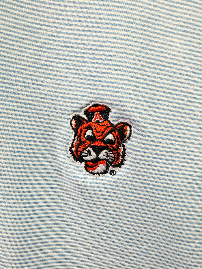 Close-up of a light blue and white striped fabric with an embroidered tiger mascot patch featuring a red letter A on its hat.