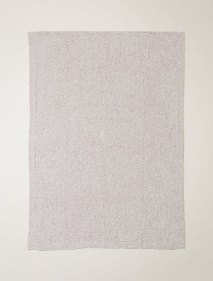 Light gray textured blanket on a white background