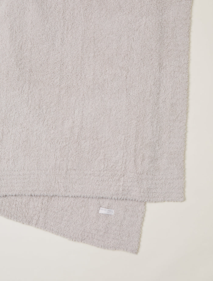 Gray textured fabric with a brand label on a light beige background