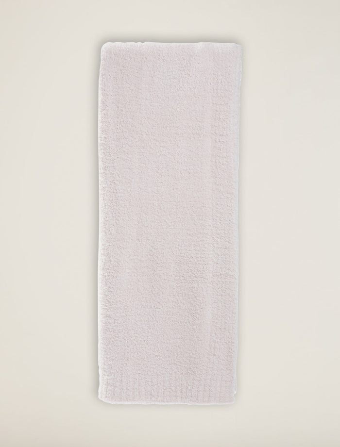 Rectangular white bath mat on a light beige background
