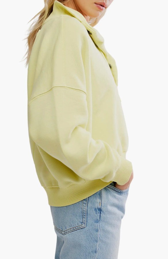 Person wearing a light yellow hoodie and blue jeans on a white background