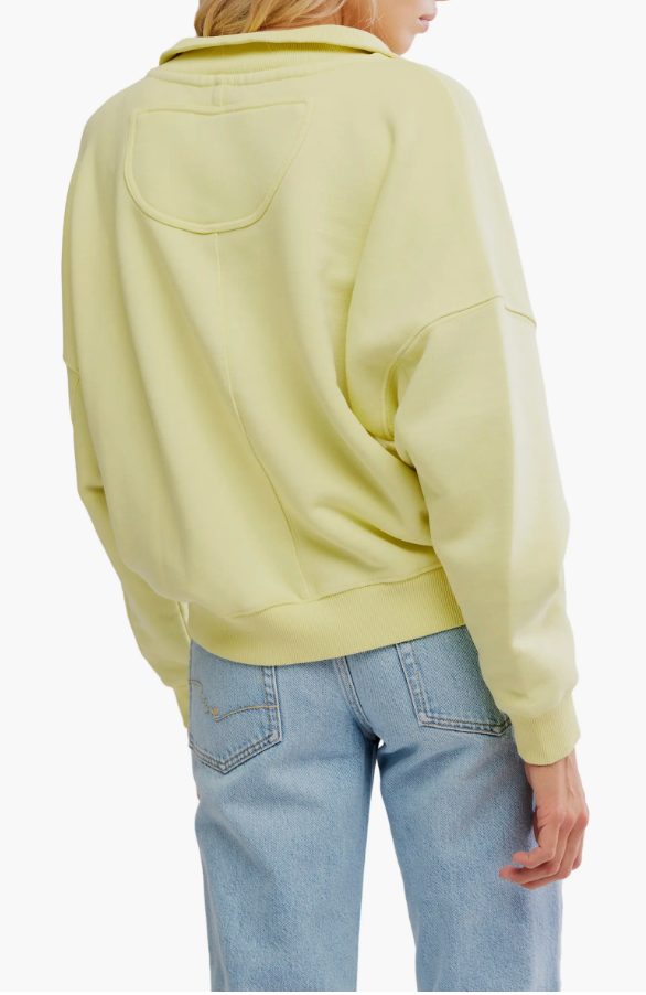 Person wearing a light yellow hoodie and blue jeans on a white background