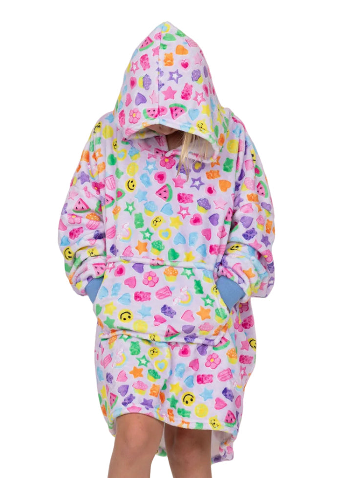 A child wearing a hooded bathrobe with a colorful smiley face, star, and heart pattern on a light pink background. The robe has blue cuffs and pockets, and the child is posed against a solid pink backdrop with small decorative stickers.