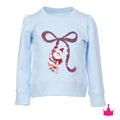 A light blue long-sleeve sweatshirt featuring a sequined graphic of a cat in a Santa outfit under a large sequined bow. The brand name 'Amigo' is visible on the inner neck label.