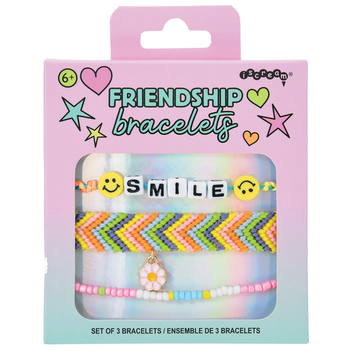 Packaged set of friendship bracelets with 'SMILE' and floral charm on a pink and blue gradient background.