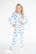 Young girl wearing a blue floral pajama set on a white background