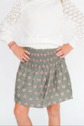 Person wearing a floral skirt on a white background