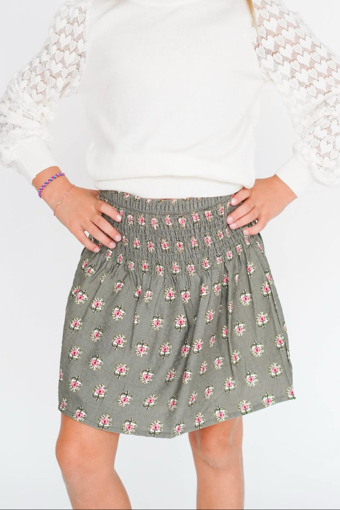 Person wearing a floral skirt on a white background