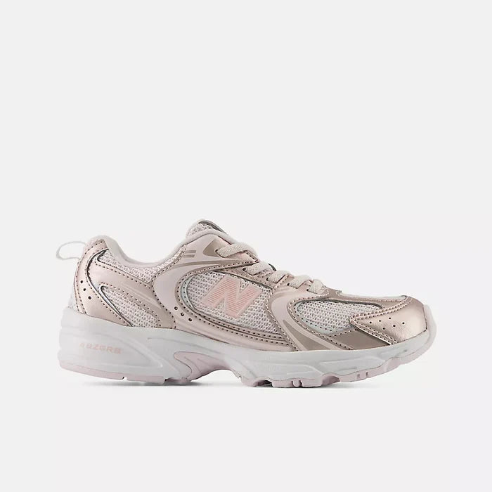 A New Balance athletic sneaker in a metallic rose gold and light pink colorway, shown from a side profile view against a light gray background.