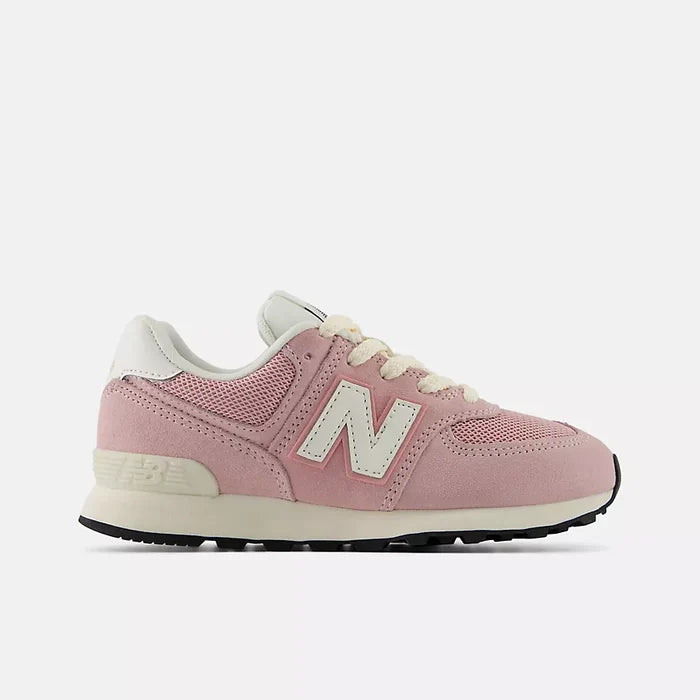 A pink New Balance sneaker with cream-colored laces, a cream 'N' logo, and a black outsole, shown in a side profile on a light gray background.