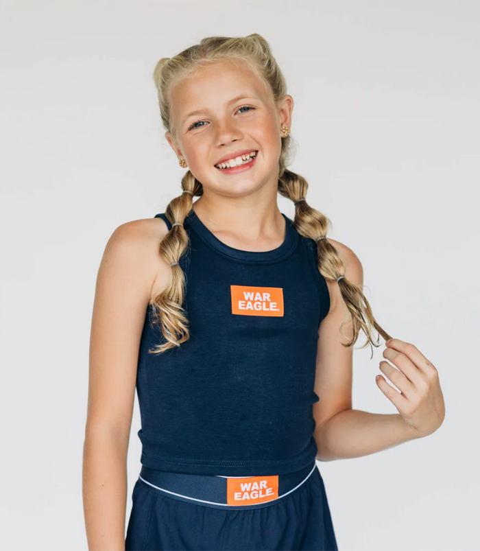 Young girl wearing a navy sleeveless top and shorts with 'War Eagle' logo on a white background