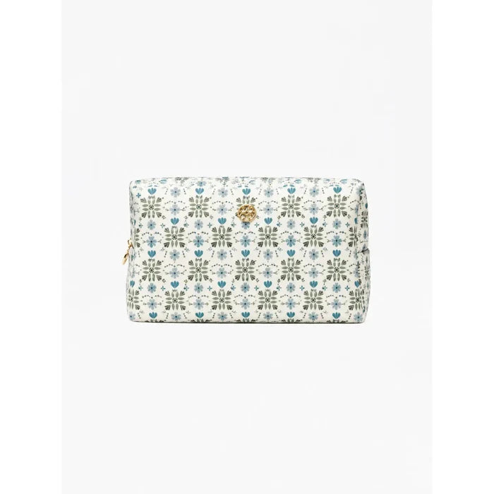 A rectangular cosmetic pouch with a white background and an all-over blue and green floral pattern, featuring a small gold-tone lion emblem on the front and a gold zipper pull on the left side.
