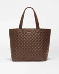 A brown quilted leather tote bag with double shoulder straps, shown against a plain light gray background.