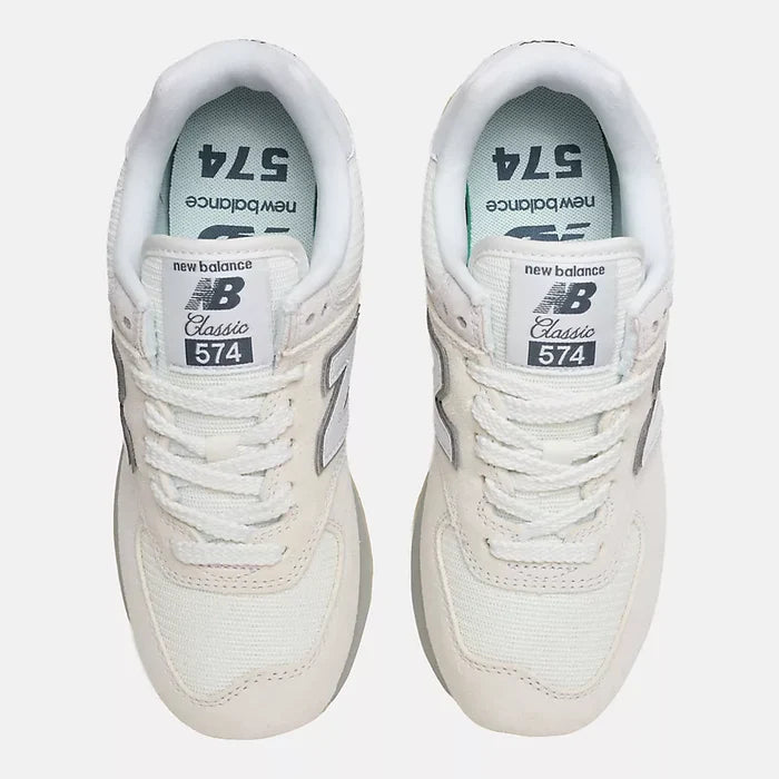 A pair of New Balance 574 Classic sneakers in off-white and light gray, shown from a top-down view on a light gray background.